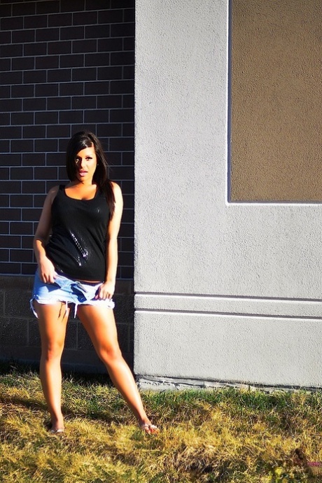 Brunette amateur Briana Lee uncovers her big boobs outside of a building 19989157