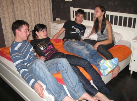 Young brunettes and their boyfriends have foursome sex on top of a bed 42970243