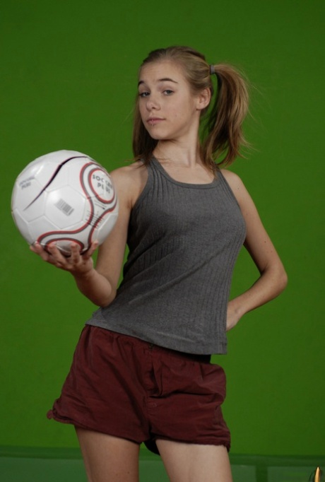 Petite girl Kelly exposes a breast while holding a soccer ball 11239810